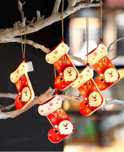 Détail de cinq chaussettes de Noël LED lumineuses avec motifs Père Noël sur une branche