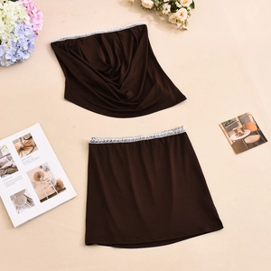 Detail van chocoladebruine set met witte kantafwerking op de buis-top en rok