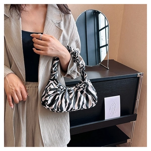 Detailed view of women's cloud bag with zebra pattern and ruched handle detail