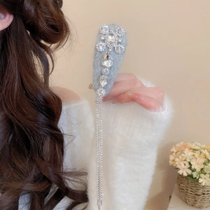 Close-up of light blue plush hair clip with water drop rhinestone tassel detail