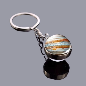 Jupiter planet double-sided glass ball keychain with silver metal base on reflective surface