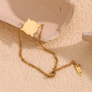 Macro shot of 18K gold-plated star bracelet with K18 engraved tag and lobster clasp