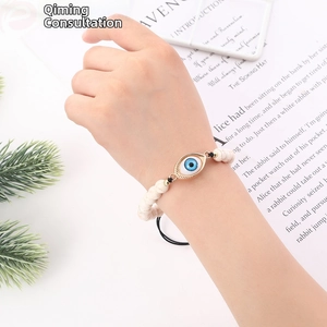 Detail of adjustable evil eye bracelet with white marble beads on lifestyle background
