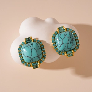 Détail de boucles d'oreilles vintage carrées en turquoise factice et strass bleus
