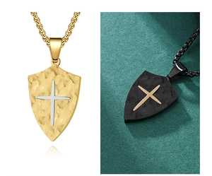 Close-up of shield pendants with cross design in gold and black textured finish