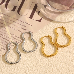 Minimalist gourd-shaped hoop earrings in gold and silver finish on a stylish background
