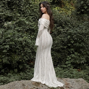 Dettaglio dell'abito a sirena in pizzo bianco con spalle scoperte e strascico lungo ed elegante