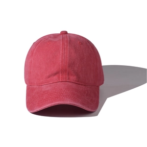 Détail d'une casquette de baseball rouge en coton lavé montrant la texture vintage et 6 pans