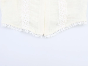 Detailed close-up of cream puff sleeve blouse featuring floral lace hem and cotton linen texture