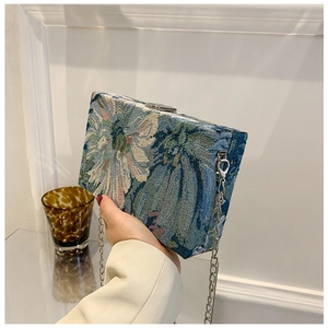 Close-up of vintage floral embroidery box bag featuring a silver chain and metal clasp