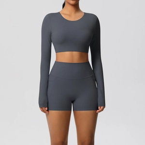 Detail van antracietgrijze yogaset met crop top met lange mouwen en shorts met zijzakken