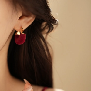 Close-up of gold-plated U-shaped earrings with burgundy flocking on female model