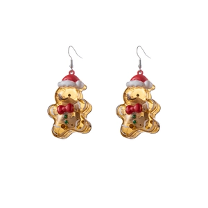 Macro shot of gingerbread man resin earrings with red hat and colorful sequins