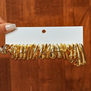 Detailed view of twenty-piece polished gold geometric earrings set on white display card
