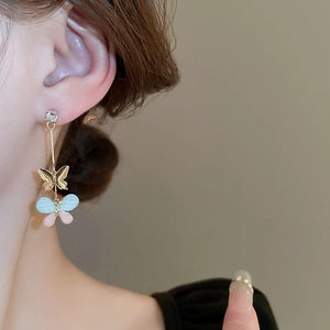 Elegant butterfly resin drop earrings with zircon accents worn by model for style
