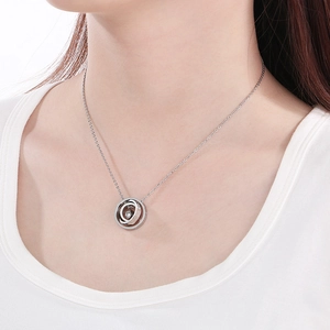 Elegant stainless steel necklace with interlocking rings and zircon stone on female model