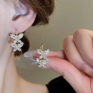 Close-up of golden butterfly earrings with sparkling crystals in a French vintage design