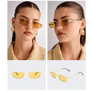 Detalle de gafas de sol cuadradas de metal con lentes ámbar y montura dorada chic