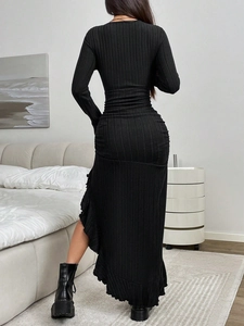 Back view of a slim black ribbed knit dress with ruffled side slit hem for autumn wear