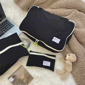 Waterproof black nylon travel organizers with yellow zipper pulls and motivation labels