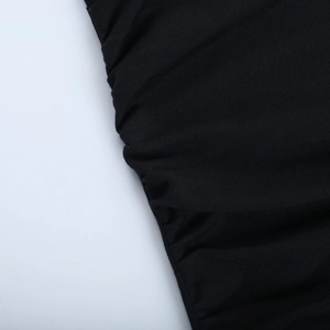 Détail de la robe en dentelle noire montrant la texture plissée du tissu en gros plan