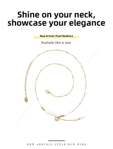 Close-up of baroque pearl necklace with golden sunburst medallion and polished chain