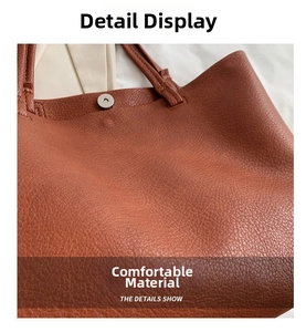 Detail of caramel leather tote bag showing lychee grain texture and metal magnetic closure