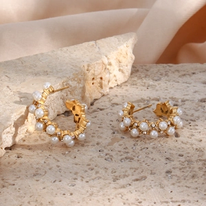 Detail of 18K gold-plated C-shaped earrings featuring white pearls and zircon accents