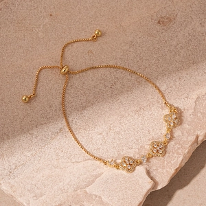 Détail du fermoir bolo ajustable en or sur bracelet trèfle avec oxydes de zirconium