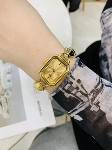 Primo piano dell'elegante orologio al quarzo ottagonale dorato con cinturino in metallo