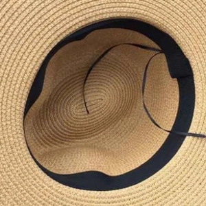 Adjustable interior of a classic straw Panama beach hat with black sweatband detail