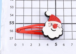 Dettaglio del fermaglio Babbo Natale con cappello glitterato rosso su carta graduata