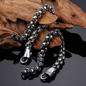 Classic stainless steel skull link bracelet in punk gothic style on dark wood background