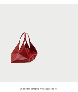 Detail of red oil wax leather handbag showing non-adjustable strap and folded texture