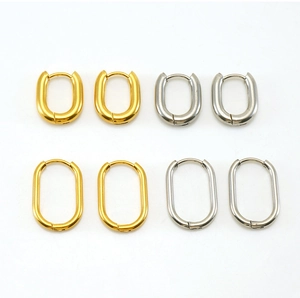 Detail of oval hoop earrings in gold and silver finish with spring clasp closure