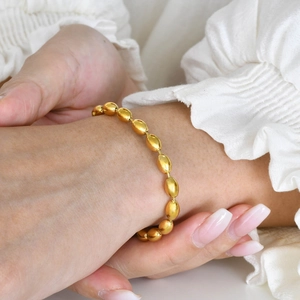 Elegant 18K gold-plated stainless steel bead bracelet worn on a woman's wrist