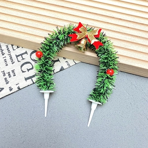 Detailed Christmas wreath cake topper with red bow, gold bell, and berries on dual white pins