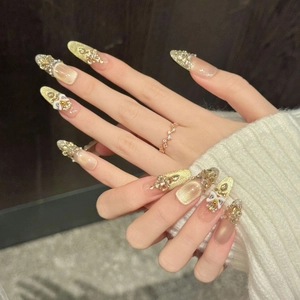 Luxurious almond press-on nails with champagne gold glitter, 3D bows and rhinestones