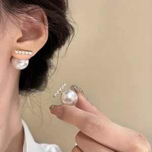 Detailed view of pearl earrings with multiple small pearls and a large back stud drop