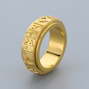 Detail of golden stainless steel spinning ring featuring engraved Nordic Viking runes