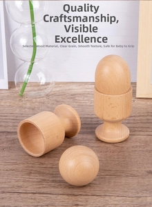 Detail of natural beech wood baby sensory toys including eggs and cups for grasping