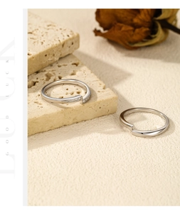 S925 sterling silver couple rings with diamond accents on a natural stone background