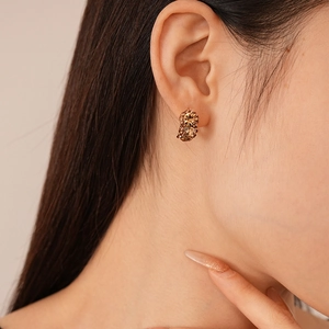Macro detail of champagne gold rhinestone stud earrings on model for a vintage look