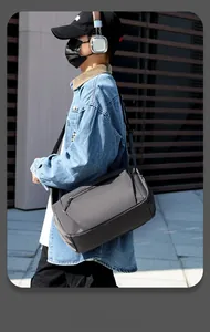 Detail of dark grey waterproof oxford fabric shoulder bag with metallic zipper on a model