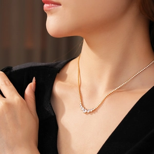 Close-up of elegant gold necklace with clear zircon stones worn on a model's neck