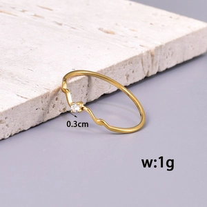 Minimalist wavy gold ring featuring a sparkling central zircon on elegant stone display