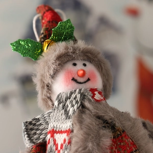 Dettaglio del pupazzo di neve in peluche di Natale con cappello a quadri e campanello