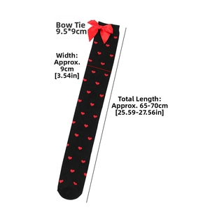 Detail of black over-the-knee socks with red heart patterns and a satin bow decoration