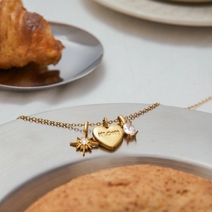 18K gold stainless steel MOM heart and star pendant necklace on a decorative metal tray