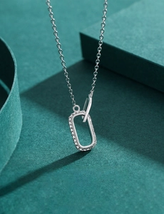 Macro shot of a geometric silver pendant necklace with micro-pave white zircon crystals